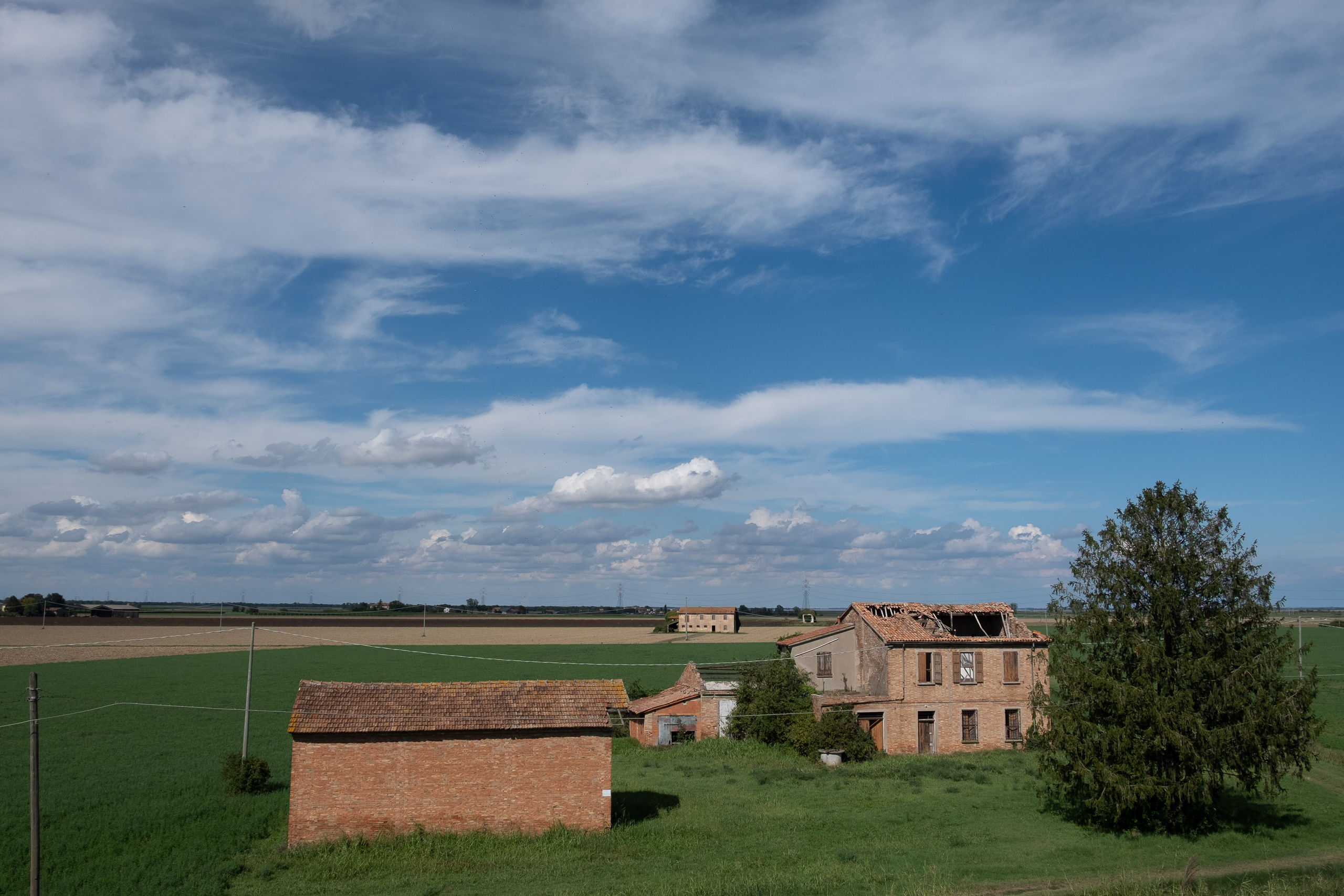 Verfallener Ziegelhof unter weitem Himmel